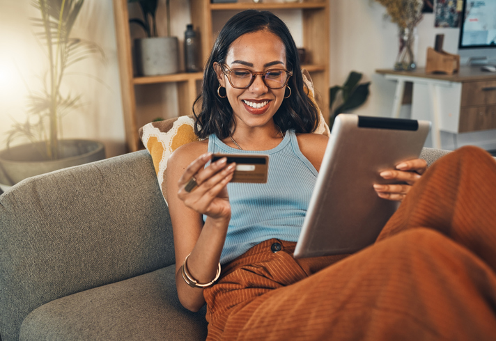 Woman looking at credit card and ipad